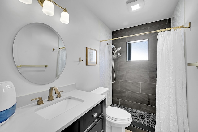 full bath with vanity, toilet, and a tile shower