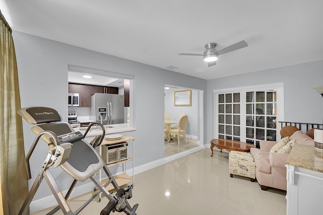 interior space featuring a ceiling fan, baseboards, light tile patterned floors, and visible vents