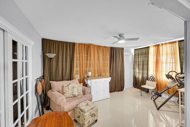 living area with ceiling fan, light tile patterned flooring, and visible vents