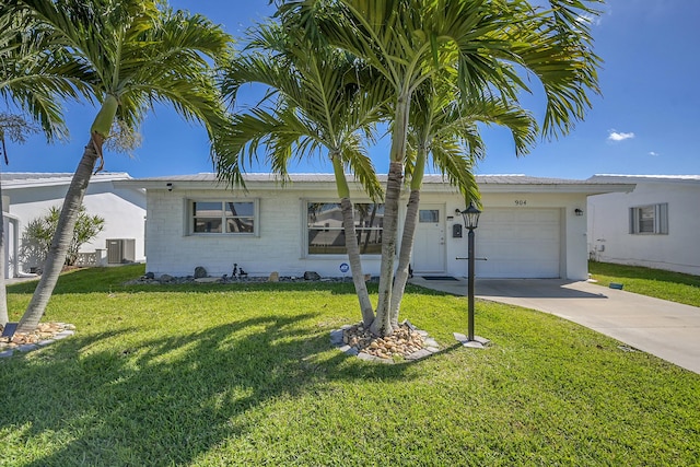 ranch-style house featuring driveway, cooling unit, an attached garage, and a front yard