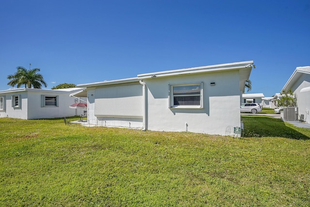 view of property exterior featuring a yard, central air condition unit, and stucco siding