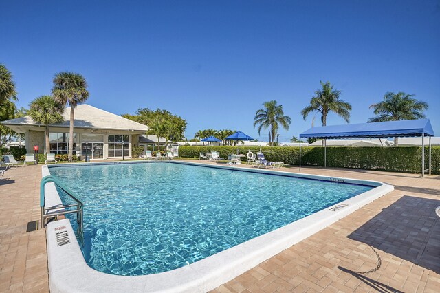 pool with a patio area and fence