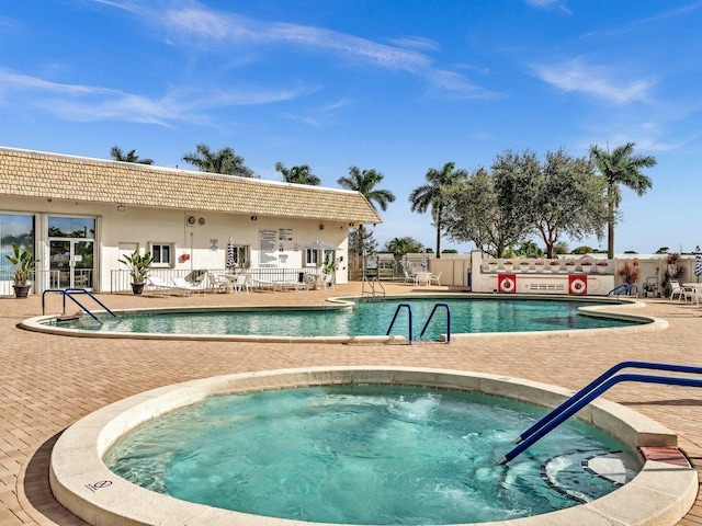 community pool with fence, a patio, and a community hot tub