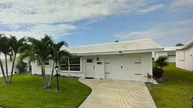 ranch-style house with a front lawn, driveway, and a garage