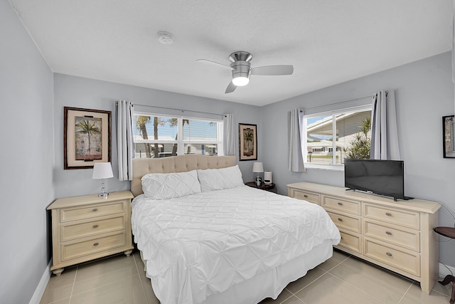 bedroom with baseboards, light tile patterned flooring, and ceiling fan