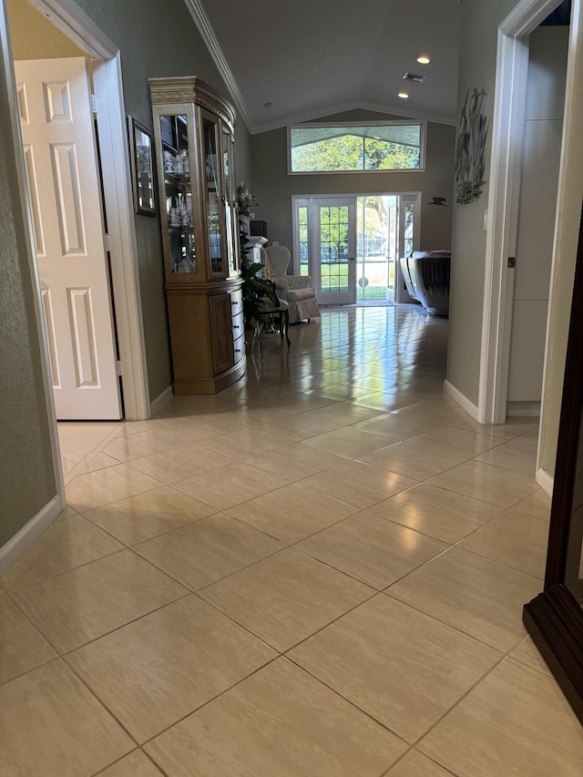 corridor with crown molding, light tile patterned floors, french doors, and vaulted ceiling