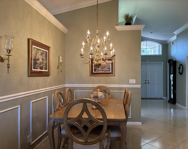 dining space with tile patterned flooring, a wainscoted wall, a chandelier, and ornamental molding