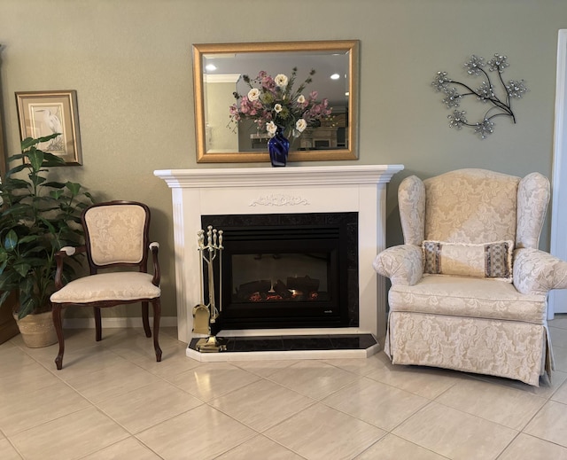 living area with a glass covered fireplace and tile patterned flooring