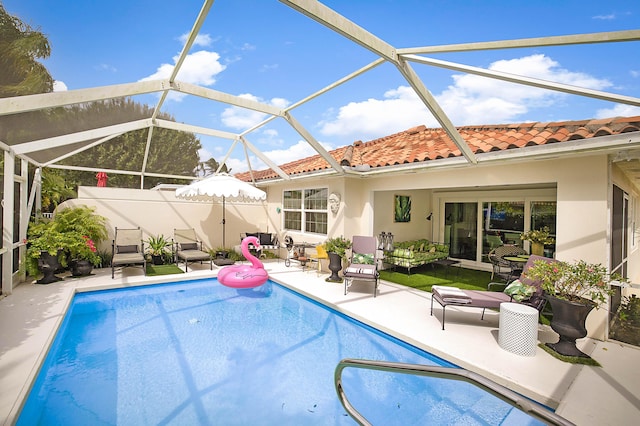 view of pool featuring glass enclosure, a patio area, and a fenced in pool