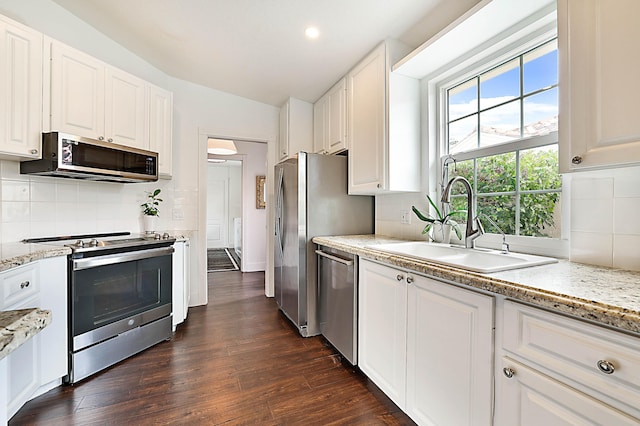 kitchen featuring a sink, appliances with stainless steel finishes, dark wood finished floors, and white cabinets