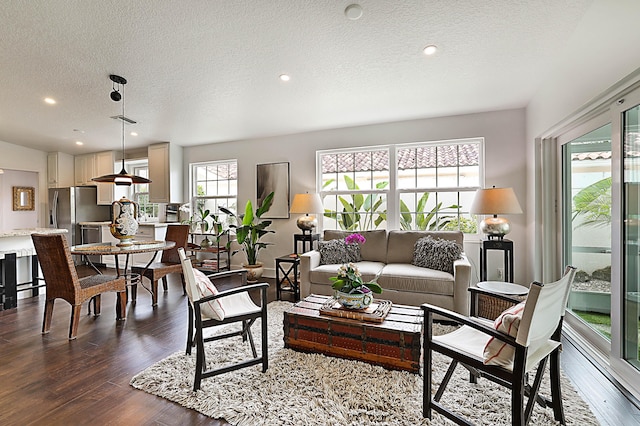 living area with recessed lighting, visible vents, a textured ceiling, and dark wood-style flooring