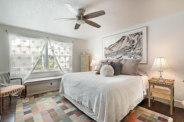 bedroom featuring a textured ceiling, a ceiling fan, and wood finished floors