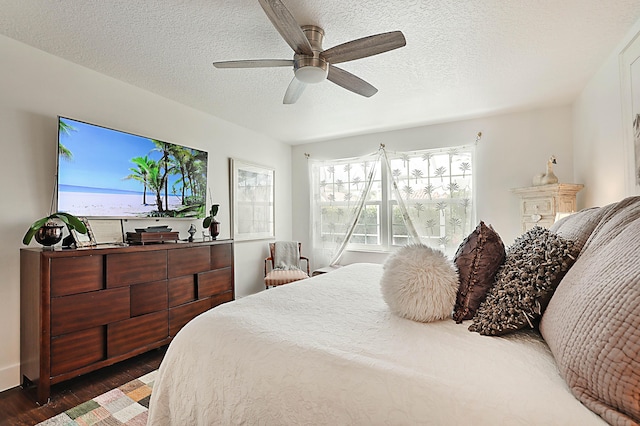 bedroom with a textured ceiling, a ceiling fan, and wood finished floors