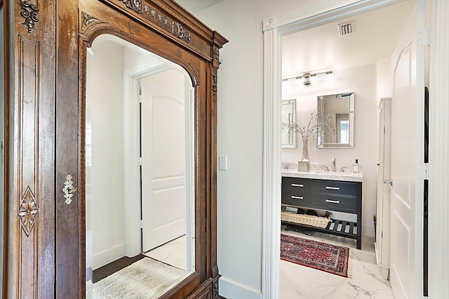 bathroom featuring vanity, baseboards, visible vents, and marble finish floor