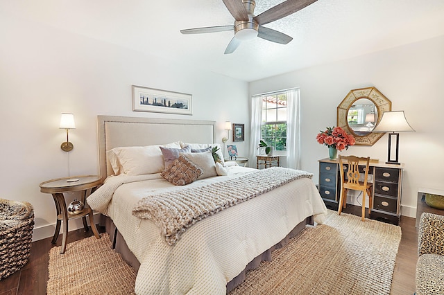 bedroom with ceiling fan, baseboards, and wood finished floors