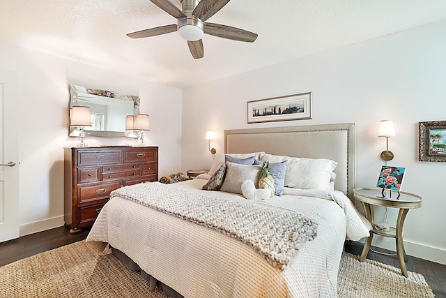 bedroom with a ceiling fan, dark wood-type flooring, and baseboards