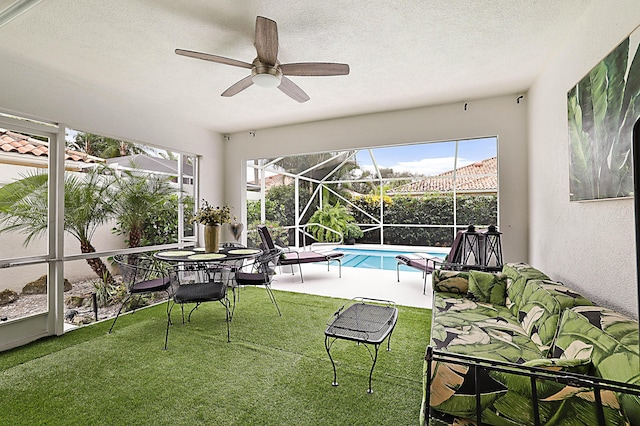 outdoor pool with a lanai, a yard, a ceiling fan, and a patio area