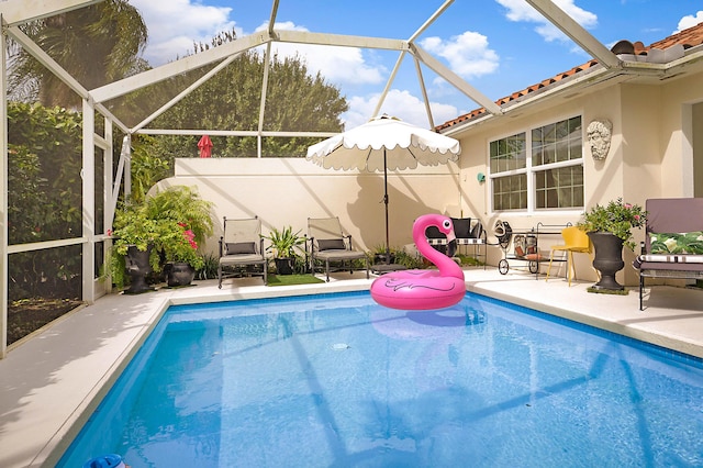 pool featuring glass enclosure and a patio