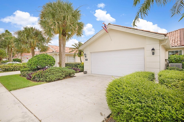 view of front of home with stucco siding, an attached garage, driveway, and a tiled roof