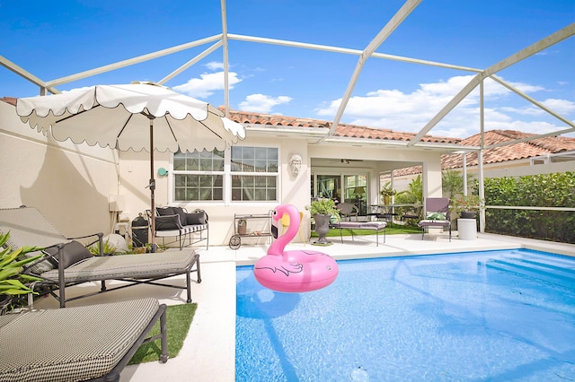 outdoor pool featuring glass enclosure, outdoor lounge area, and a patio