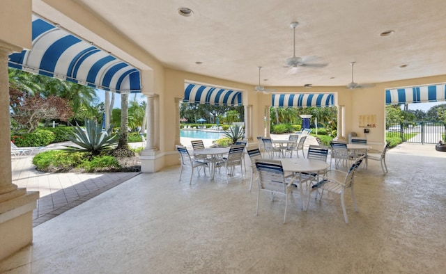 view of patio / terrace featuring outdoor dining area, a community pool, and fence