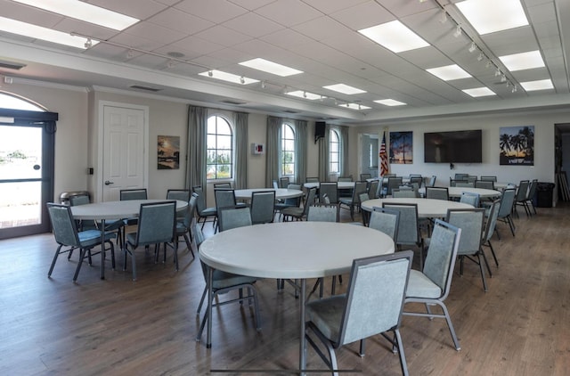 dining area with visible vents, ornamental molding, rail lighting, and wood finished floors