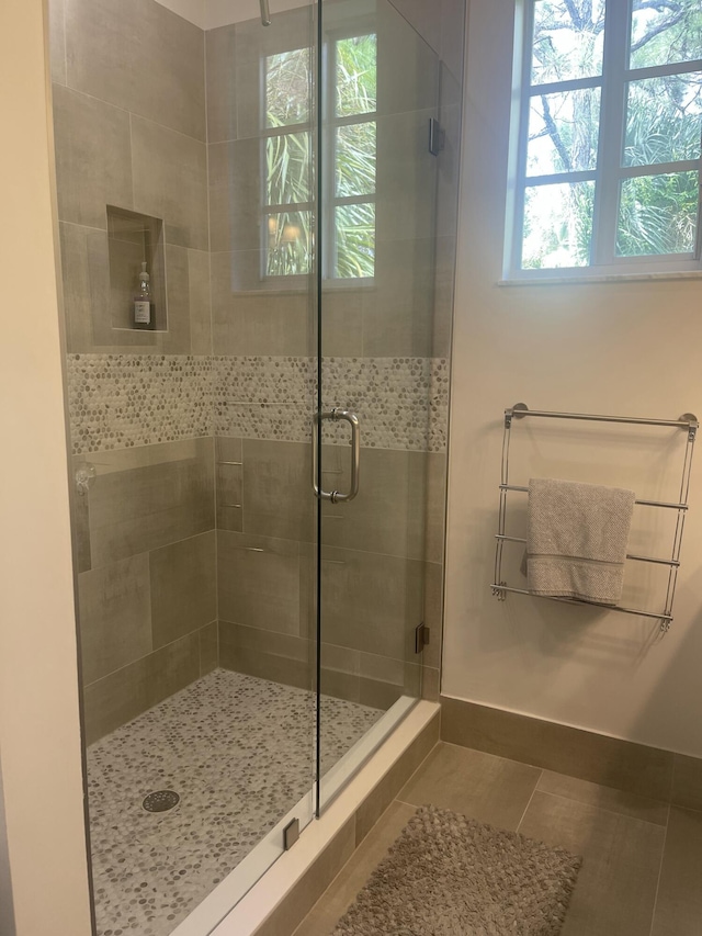 full bathroom with tile patterned floors, a shower stall, and baseboards