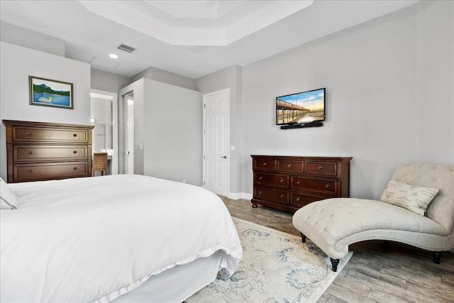 bedroom featuring visible vents, ensuite bath, wood finished floors, recessed lighting, and baseboards