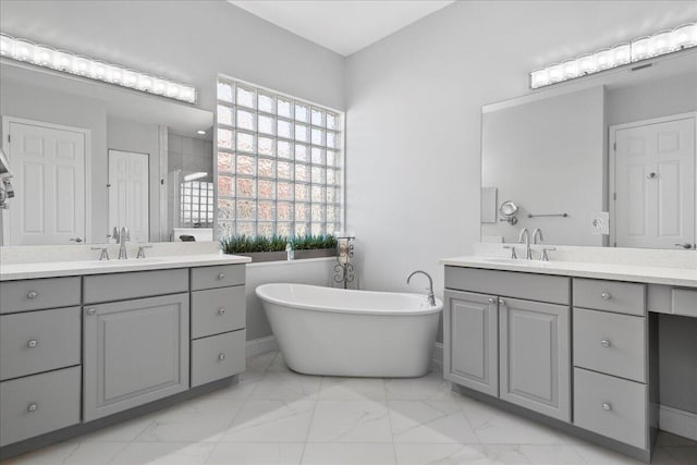 full bathroom featuring two vanities, marble finish floor, and a sink