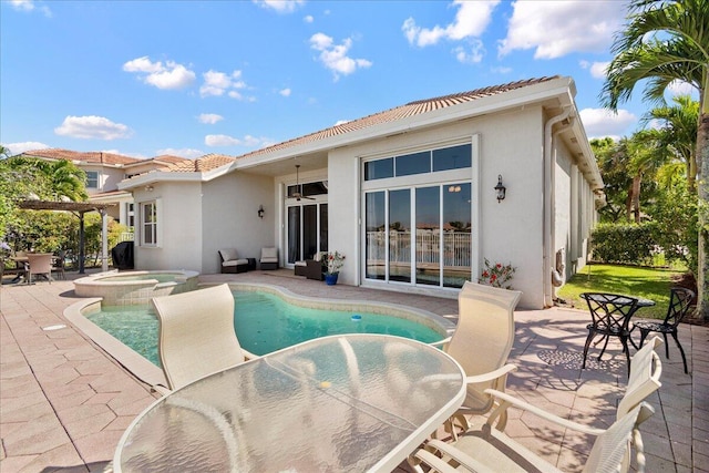 view of swimming pool with a patio area, a pool with connected hot tub, a pergola, and outdoor dining area