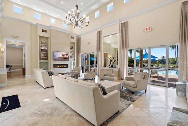 living area with visible vents, ornamental molding, baseboards, a chandelier, and a tile fireplace