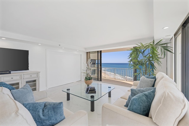 living room with recessed lighting, a water view, and marble finish floor