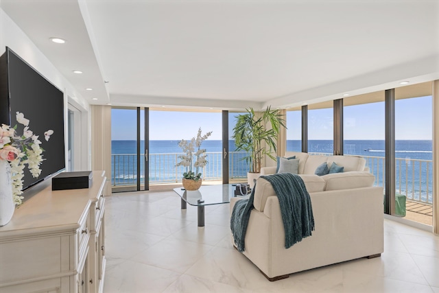 living area with a wall of windows, recessed lighting, a water view, and a wealth of natural light