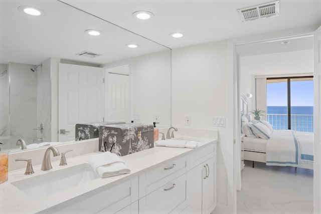 ensuite bathroom with a sink, visible vents, and double vanity