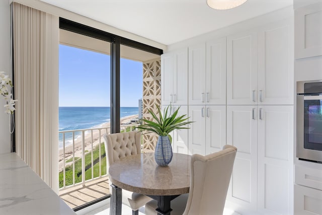 dining room featuring a water view and a beach view