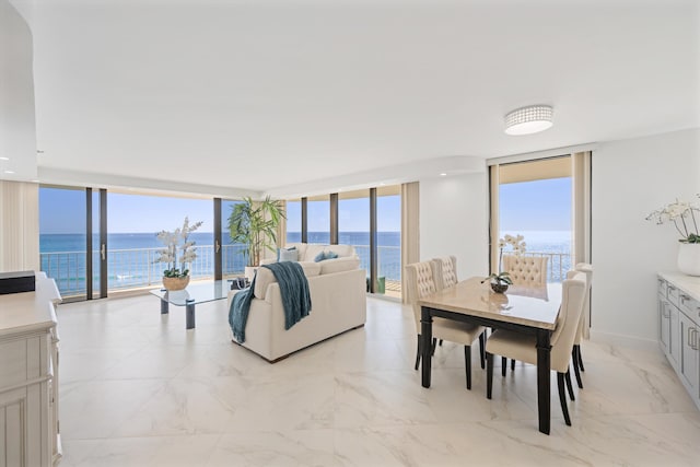 dining room with a healthy amount of sunlight, a water view, and expansive windows