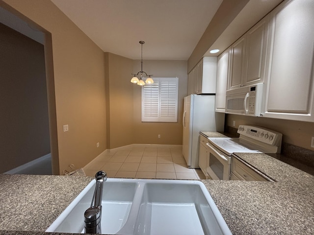 kitchen featuring light tile patterned floors, hanging light fixtures, a notable chandelier, white appliances, and a sink