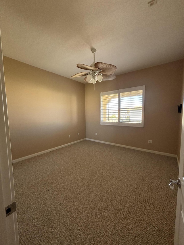 spare room featuring baseboards, a ceiling fan, and carpet flooring