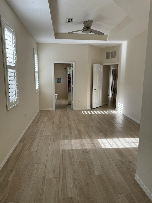 560 SW Indian Key Dr S, Saint Lucie West, FL 34986 - spare room featuring visible vents, a ceiling fan, light wood finished floors, and a tray ceiling