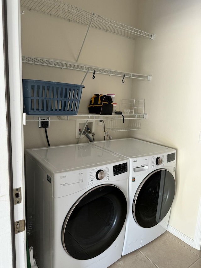 560 SW Indian Key Dr S, Saint Lucie West, FL 34986 - laundry area with tile patterned floors, washer and dryer, laundry area, and baseboards