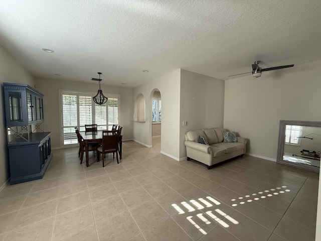 560 SW Indian Key Dr S, Saint Lucie West, FL 34986 - living area featuring baseboards, arched walkways, a textured ceiling, and light tile patterned flooring