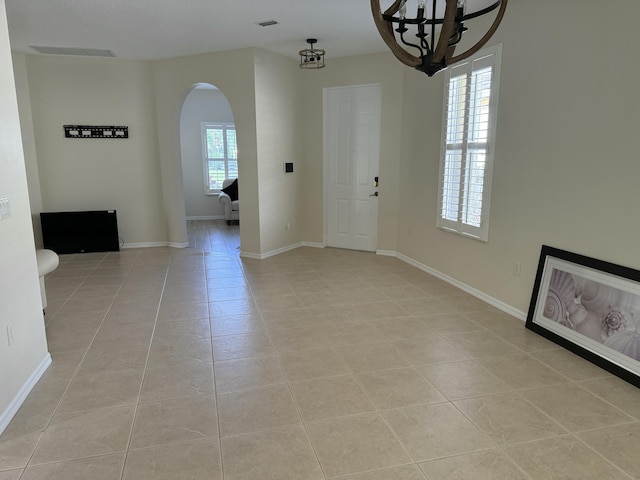 560 SW Indian Key Dr S, Saint Lucie West, FL 34986 - unfurnished dining area featuring light tile patterned flooring, baseboards, a notable chandelier, and arched walkways