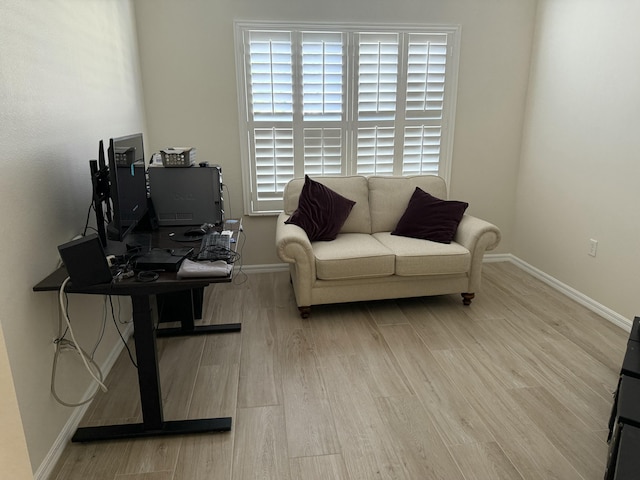 living room featuring baseboards, plenty of natural light, and wood finished floors