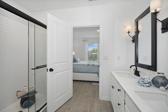 bathroom featuring a stall shower, ensuite bath, wood tiled floor, and a sink