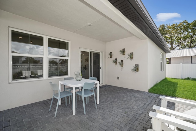 view of patio with outdoor dining space and fence