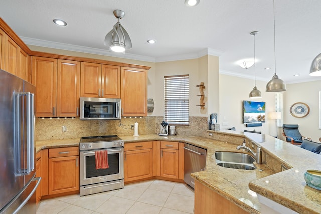 kitchen featuring light stone counters, ornamental molding, stainless steel appliances, and a sink