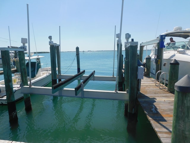 view of dock with boat lift and a water view