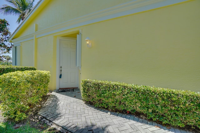 doorway to property featuring stucco siding