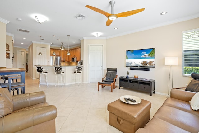 living area featuring crown molding, light tile patterned floors, and visible vents