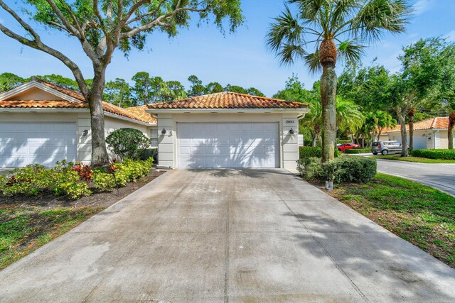 2853 White Trout Ln, West Palm Beach, FL 33411 - mediterranean / spanish home with a tiled roof, stucco siding, and a detached garage